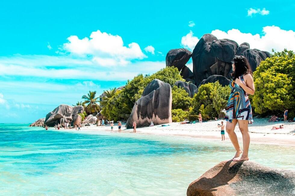 Woman standing on a rock at Anse Source DARgent, Seychelles
