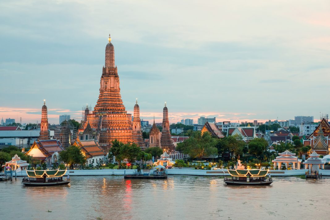 Wat Arun and cruise ship in night ,Bangkok city ,Thailand most visited cities