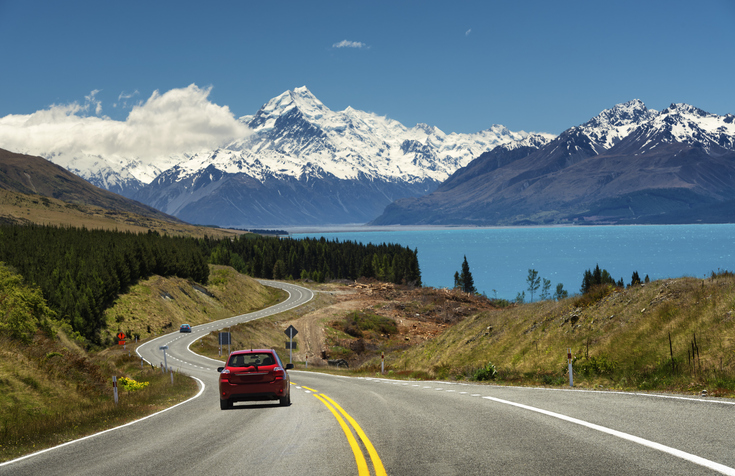 Red car going to the beautiful landscape lake tekapo, Mt.cook, Lupines fields, South island New Zealand